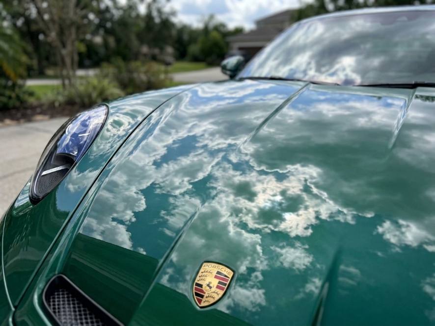 Glossy ceramic-coated hood reflecting clouds