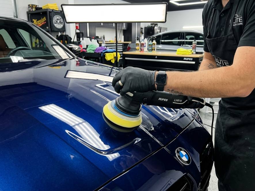 Machine polishing a dark blue hood