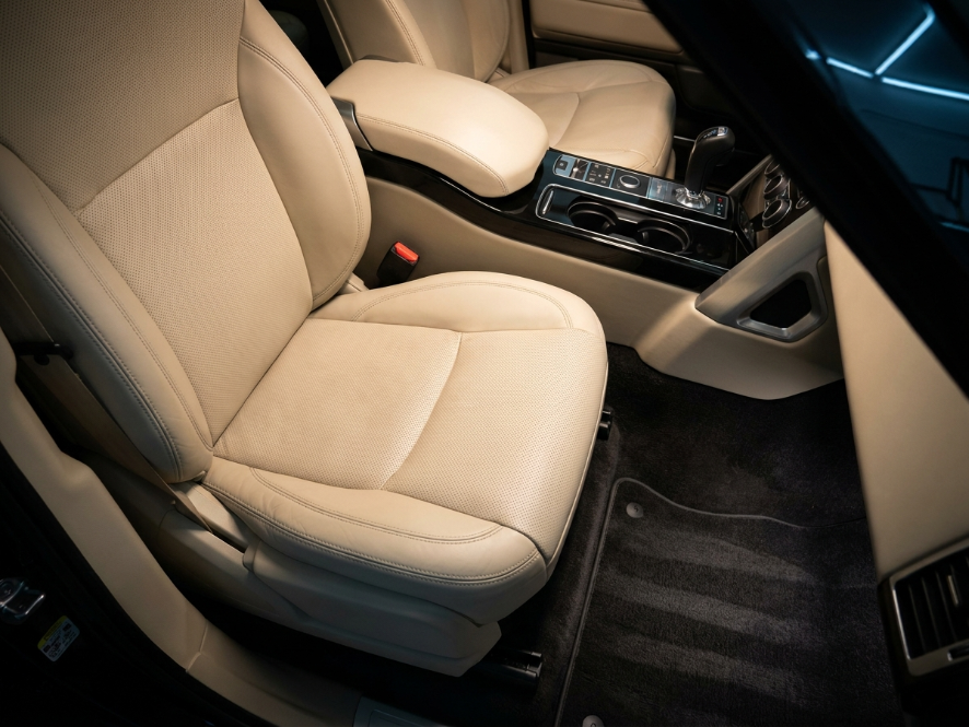 The same luxury SUV interior after detailing — spotless cream leather and fresh carpet